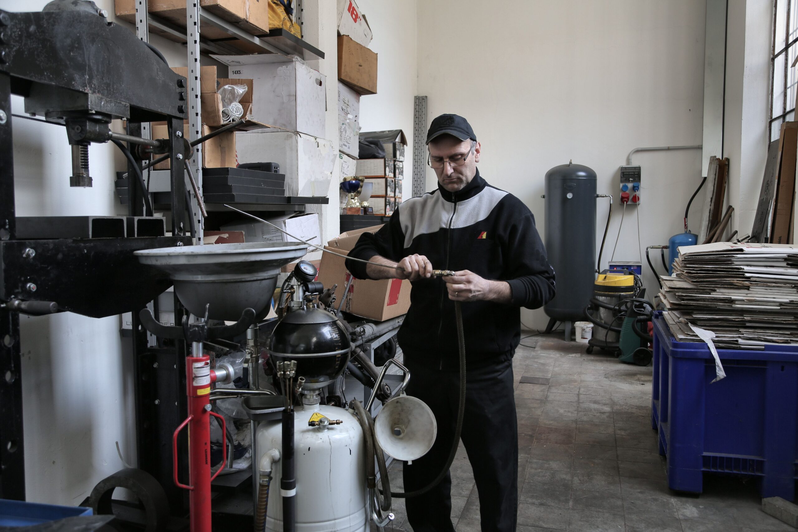 Technicien en train de réparer un tuyau hydraulique dans un atelier professionnel